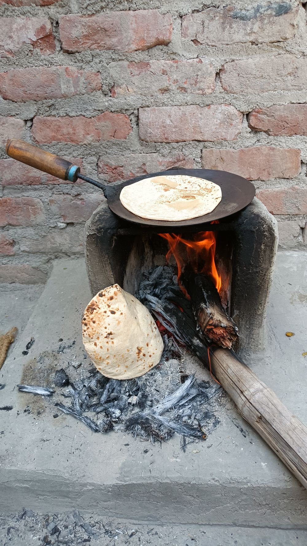 चुलीच्या आगीवर भाजली जाणारी भाकरी