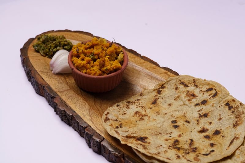 मटण भाकरी ठेच्यासह लाकडी ताटलीत